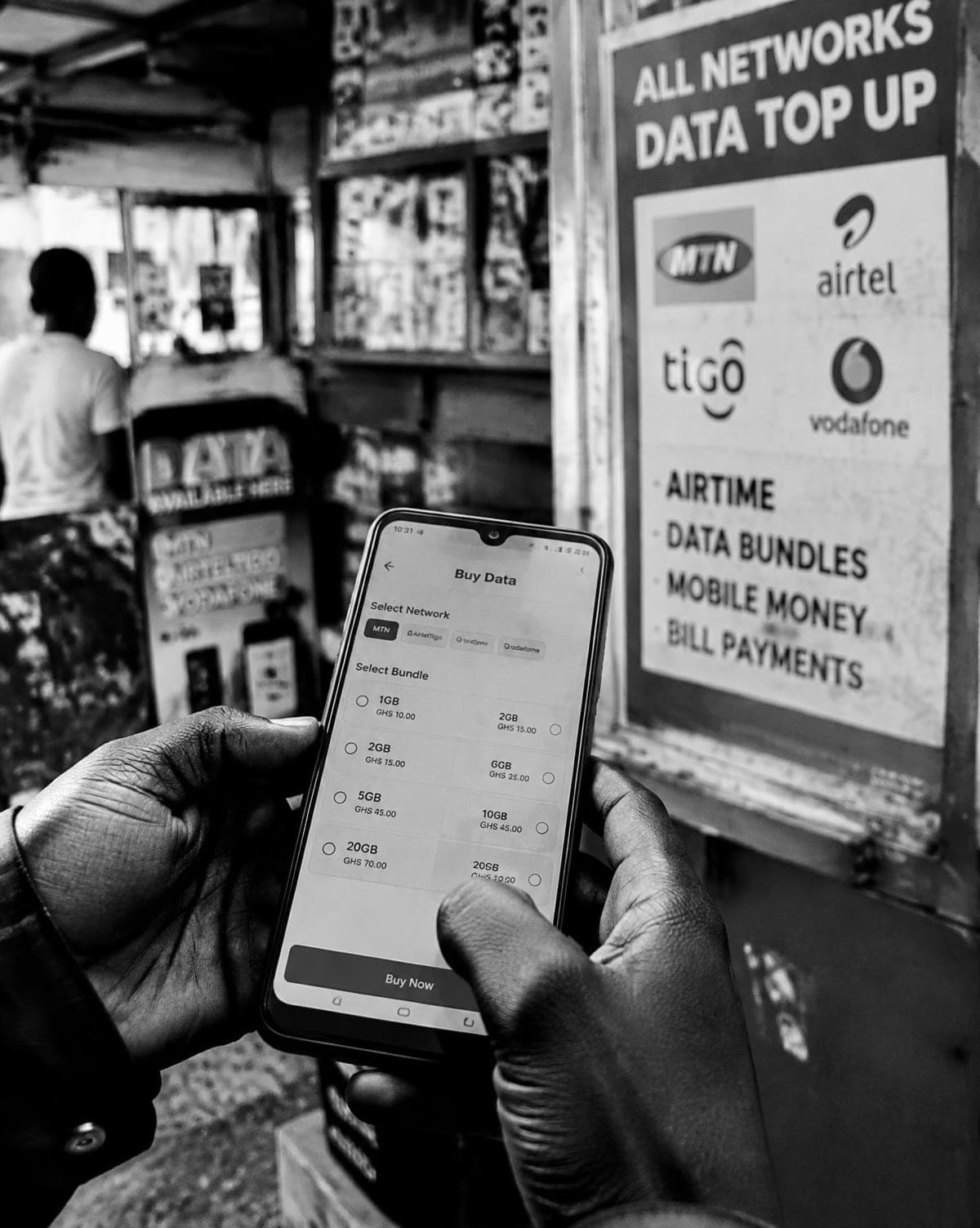 Hands buying a mobile data bundle at a street kiosk